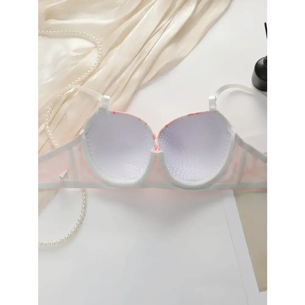 The Lady's Haven Boutique gathering bra and panty set with steel ring displayed on white surface with pearl necklace