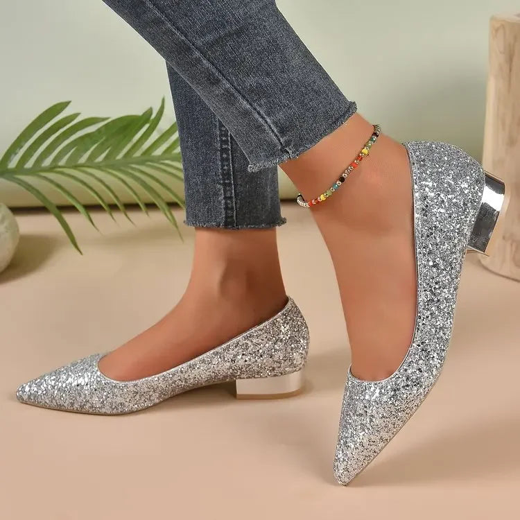 Silver glittery flats for parties with low heels worn with denim jeans and colorful ankle bracelet