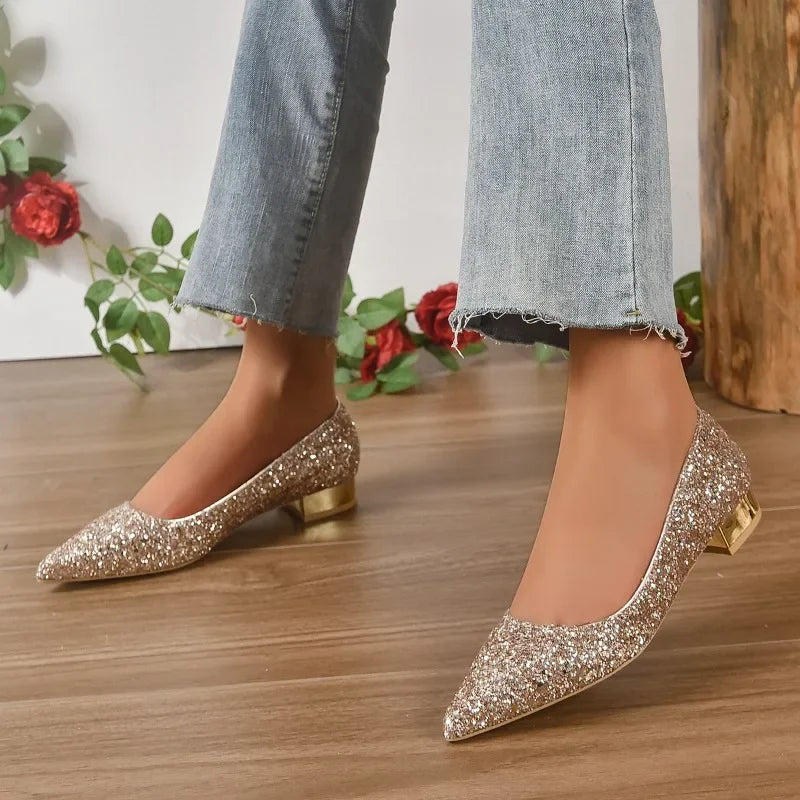 Glittery flats for parties in gold sparkle with low block heels worn with cropped blue jeans