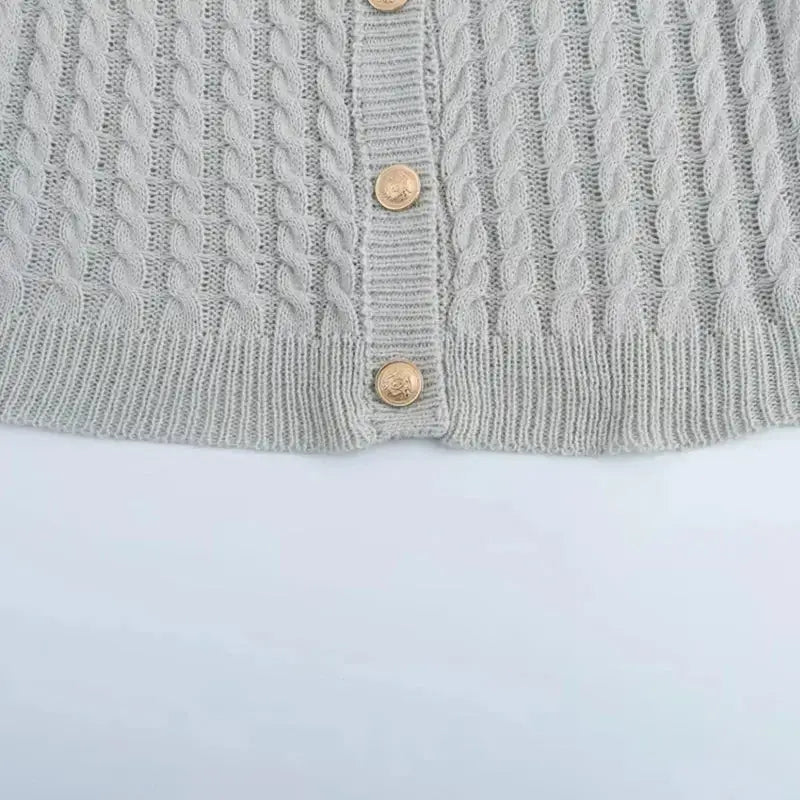 Close-up of gray cable knit cropped sweater cardigan with gold buttons from The Lady's Haven Boutique