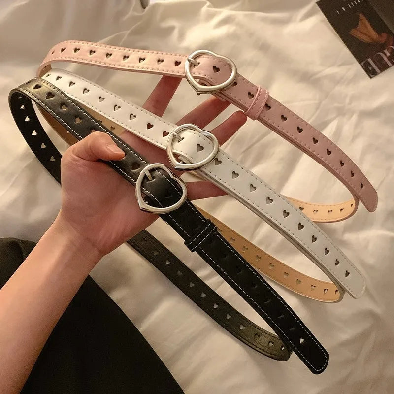 Heart buckle waist belt collection in pink, white, and black with perforated hearts design