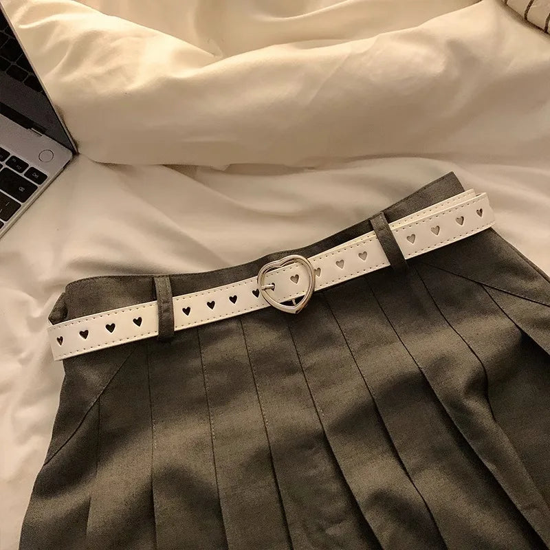 Stylish heart buckle waist belt in white featured on a gray skirt for a trendy look