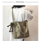 Stylish model showcasing high capacity waterproof nylon handbags with a cute plush accessory