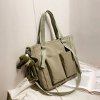 High capacity waterproof nylon handbags in beige with multiple pockets and an attached plush toy
