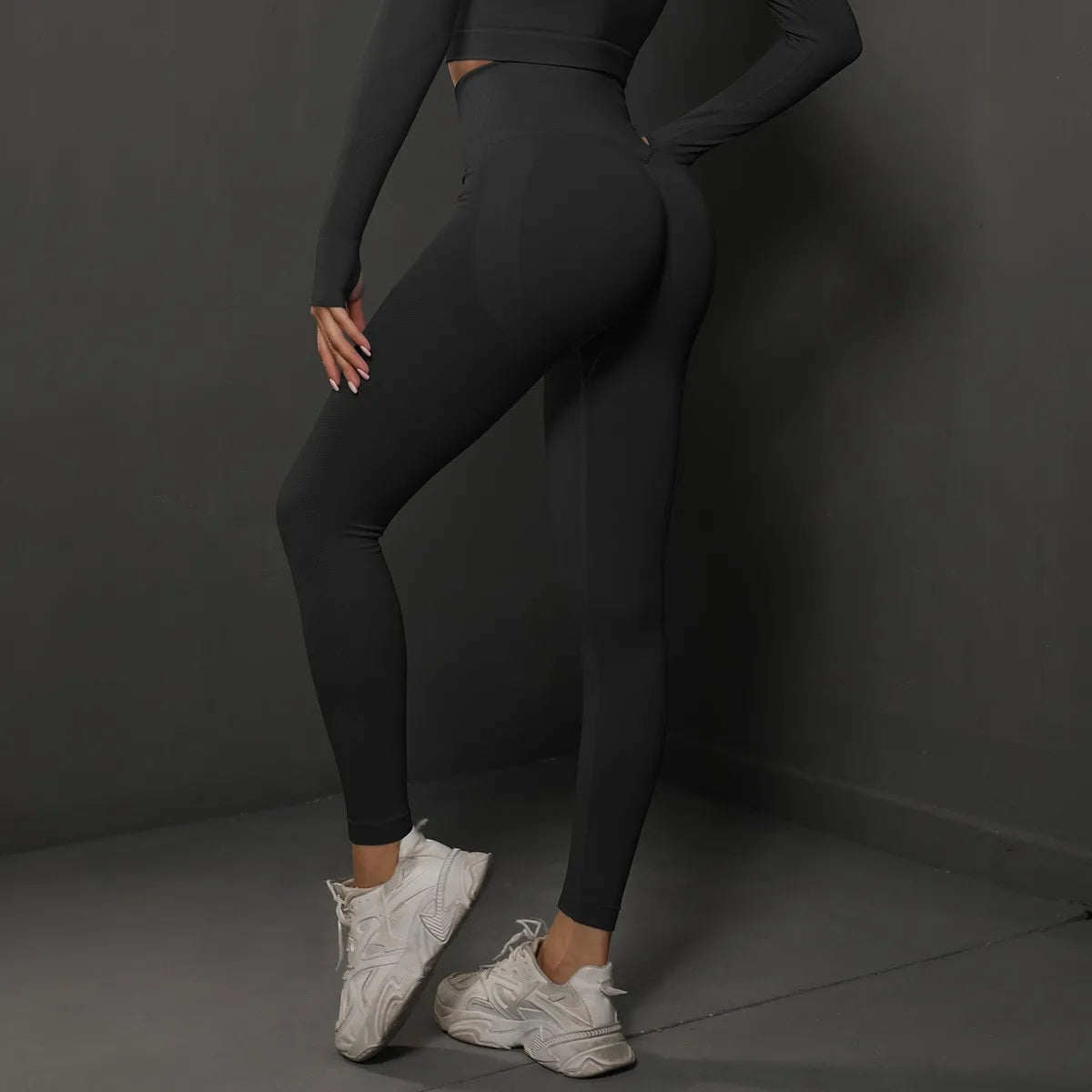 Model wearing high waist seamless yoga leggings in black, paired with white sneakers for a stylish workout look