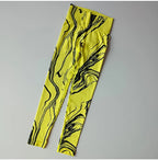 Bright yellow high waisted printed leggings with black abstract swirl design for stylish athleisure wear