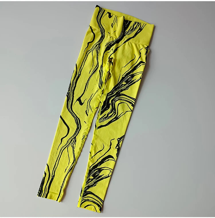 Bright yellow high waisted printed leggings with black abstract swirl design for stylish athleisure wear