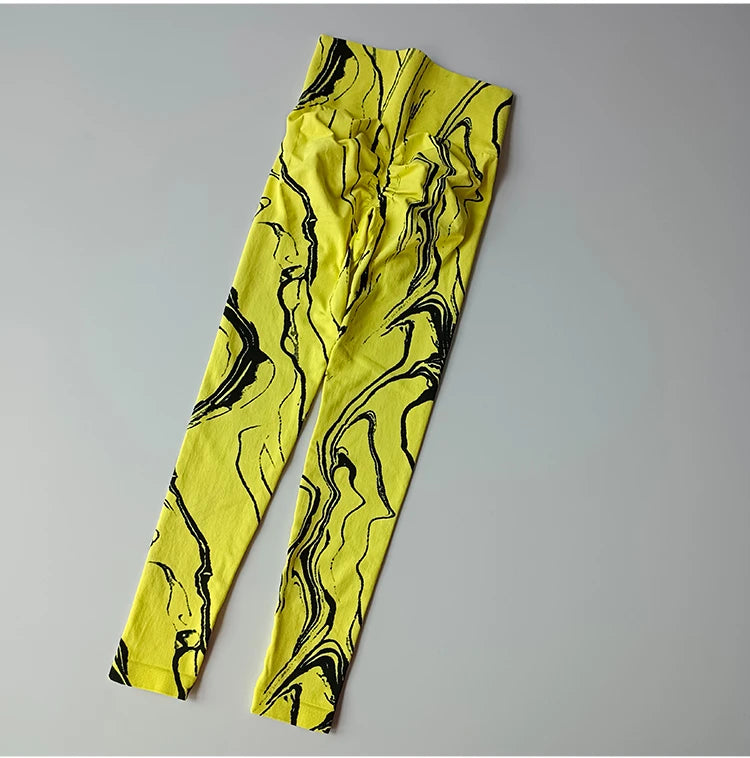 High waisted printed leggings in vibrant yellow with black abstract marble design for stylish comfort