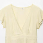 Light yellow short sleeve blouse and pant set from The Lady's Haven Boutique with a deep V neckline