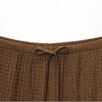 Close-up of brown textured fabric waistband with drawstring detail on two piece wide leg pant set