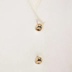 Close-up of white crop sweater vest with gold buttons from The Lady's Haven Boutique
