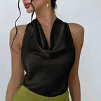 Black satin halter crop top with draped neckline styled with green pants by The Lady's Haven Boutique