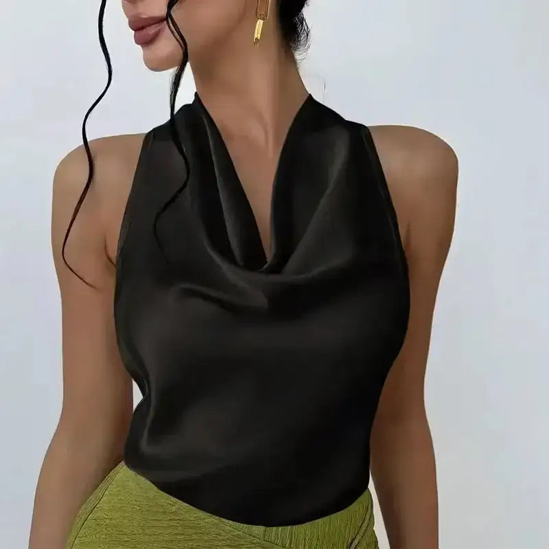 Black satin halter crop top with draped neckline styled with green pants by The Lady's Haven Boutique