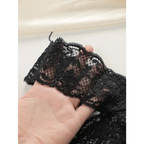 Black lace thong underwear for women being held to show delicate floral lace detail