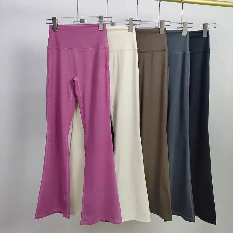 Ladies bell-bottom yoga pants in multiple colors hanging on a display rack