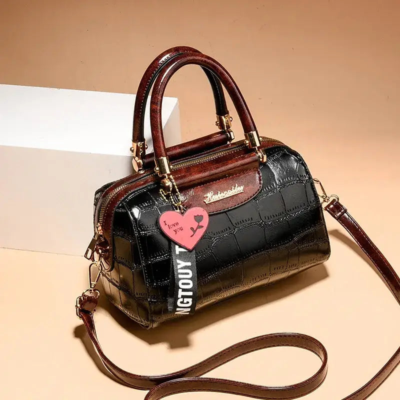 Stylish ladies designer shoulder handbag in black with brown accents and a trendy tag