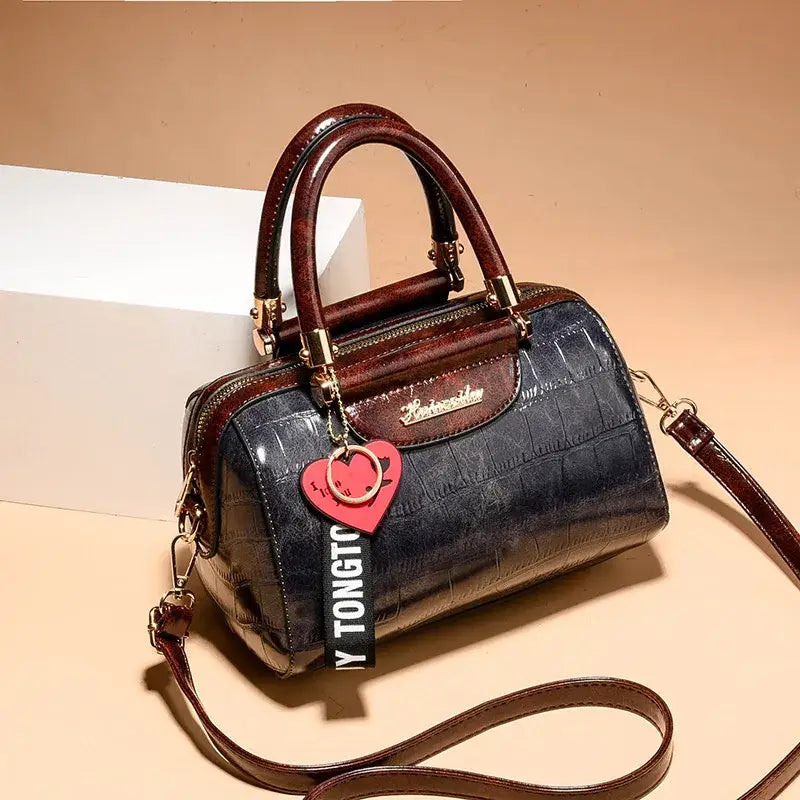 Ladies designer shoulder handbag in black and brown with stylish charm and adjustable strap