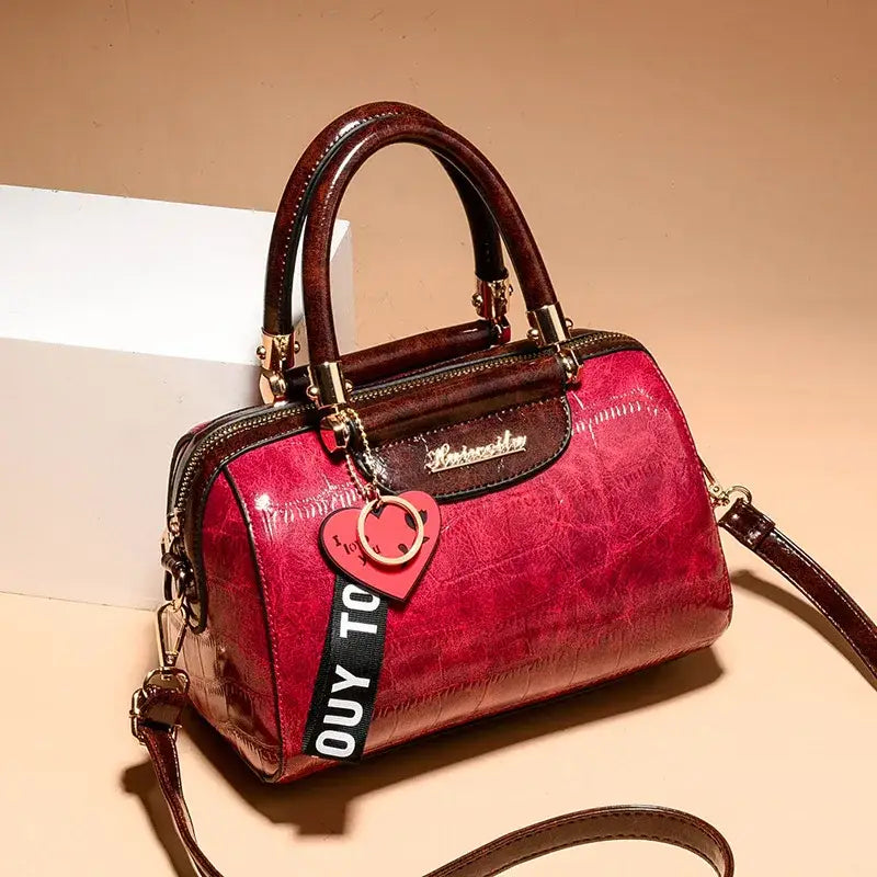 Ladies designer shoulder handbag in red with glossy finish and detachable strap from The Lady's Haven Boutique