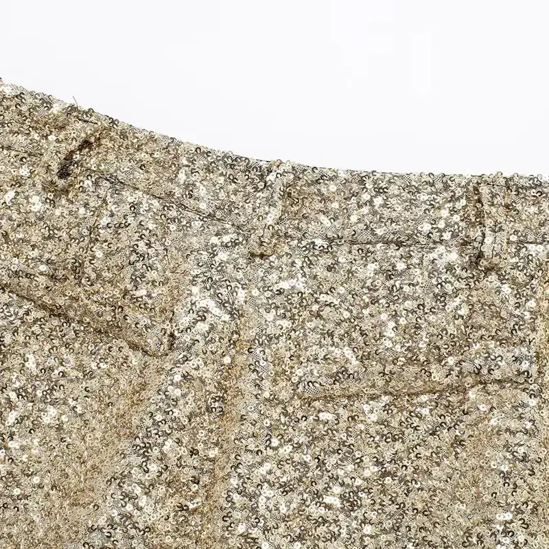 Close-up of elegant mid waist sequin shorts in shimmering gold with detailed waistband stitching