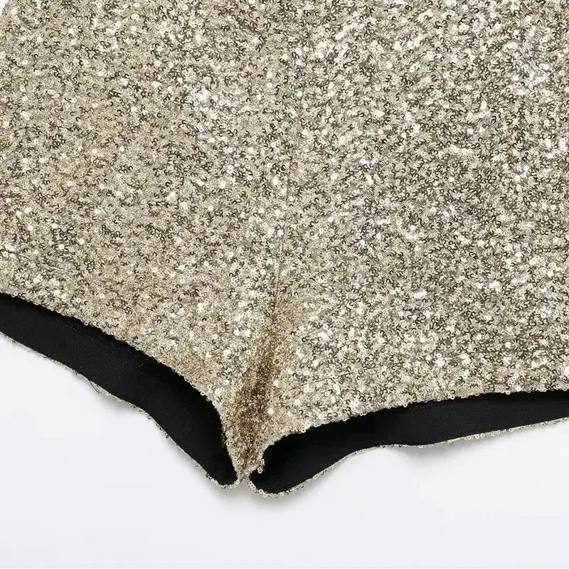 Close-up of elegant mid waist sequin shorts with gold sparkle detailing and black inner lining