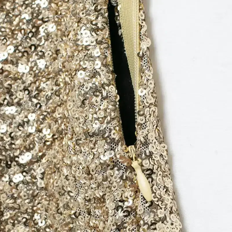 Close-up of zipper detail on elegant mid waist sequin shorts with gold sequins