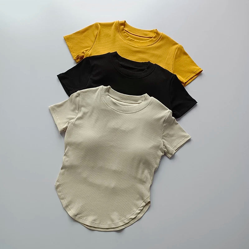 Three ladies fitness crop tops in yellow, black, and cream for stylish and comfortable workouts