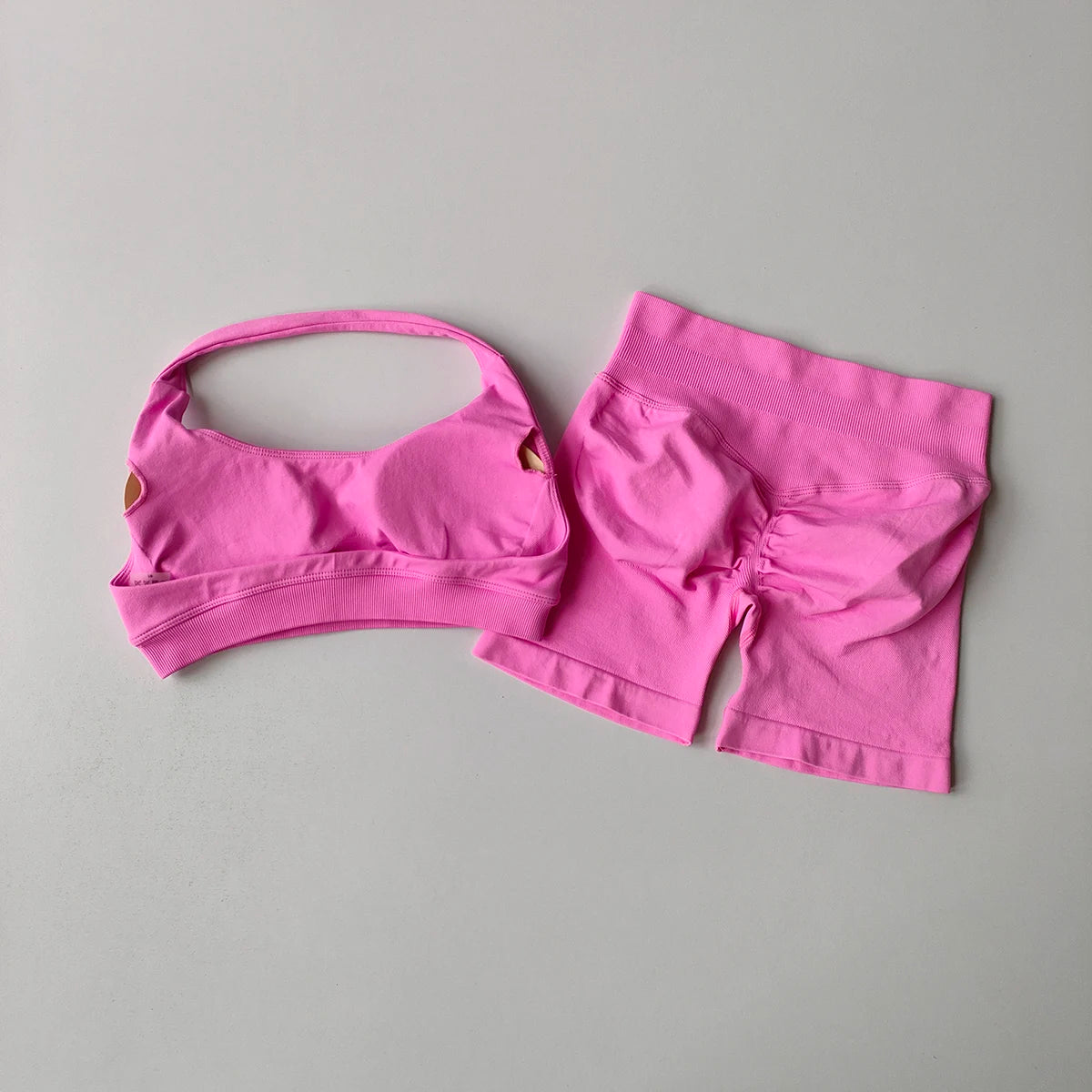 Bright pink ladies fitness outfit matching set featuring a sports bra and shorts for active women