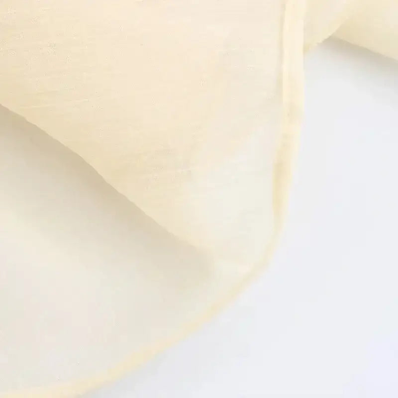 Close-up of soft cream fabric detail of long sleeve fashionable blouses from The Lady's Haven Boutique