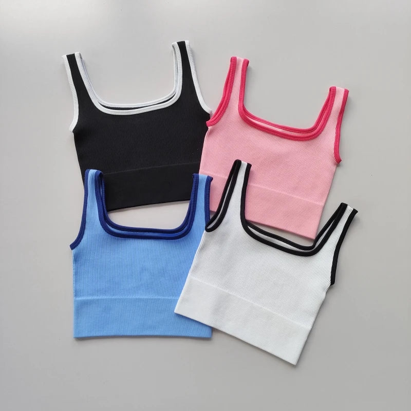 Ladies seamless yoga vest available in black, pink, blue, and white colors for comfortable workouts
