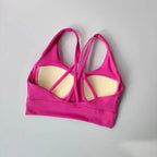 Bright pink ladies two piece gym suit top with crisscross strap design for stylish workouts