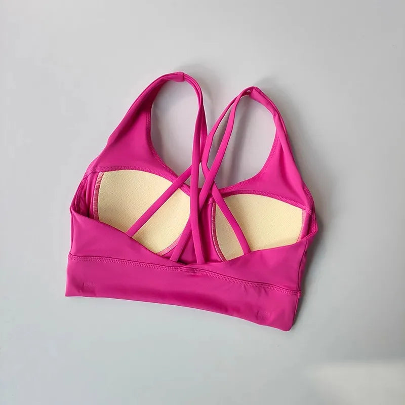 Bright pink ladies two piece gym suit top with crisscross strap design for stylish workouts