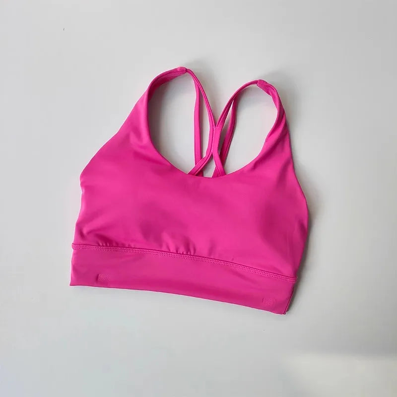 Ladies two piece gym suit featuring a stylish pink sports bra with crisscross straps
