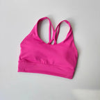 Vibrant pink ladies two piece gym suit with stylish cross-back design for activewear enthusiasts