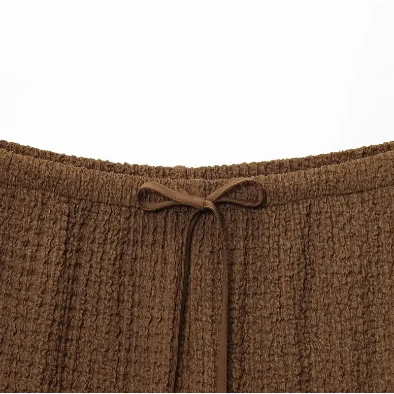 Close-up of brown textured fabric waistband with drawstring detail on two piece wide leg pant set