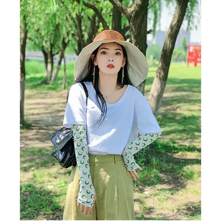 Stylish woman wearing a UPF 50 sun protection hat, paired with a casual outfit in a sunny park