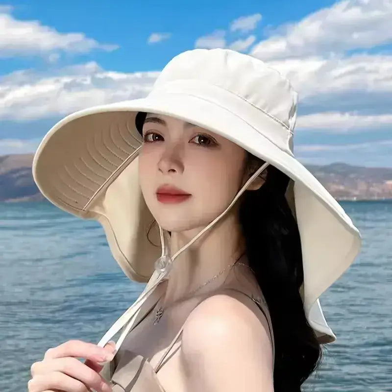 Model wearing a ladies UV sun protection bucket hat by The Lady's Haven Boutique at the beach