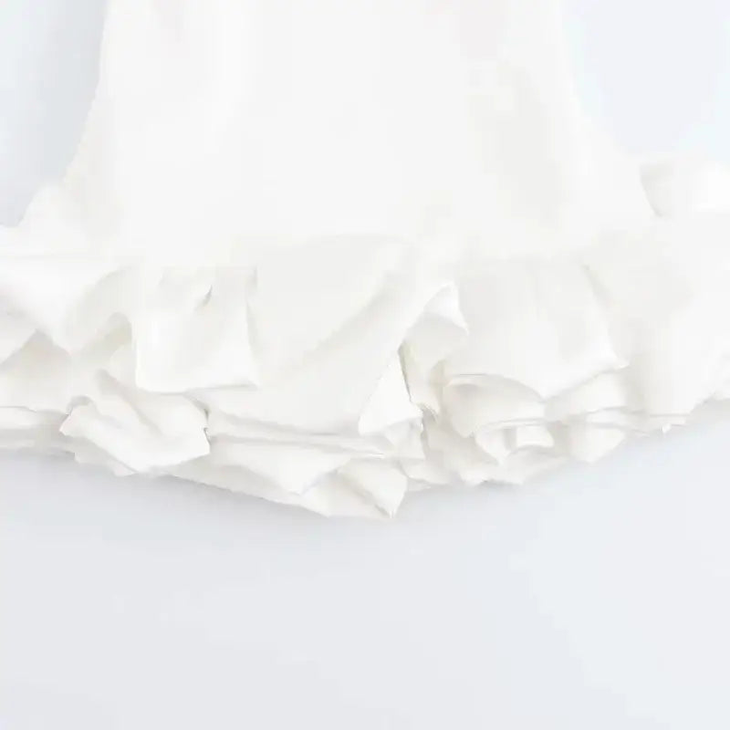 Close-up of ruffled hem detail on white summer party mini dress from The Lady's Haven Boutique