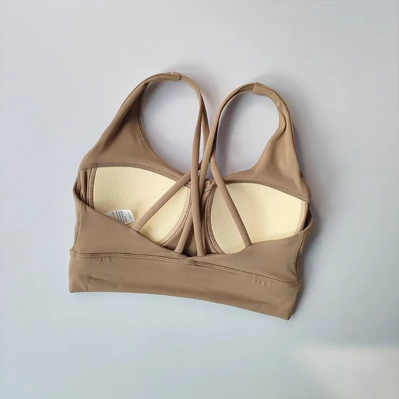 Beige ladies workout clothes set featuring a stylish strappy sports bra design