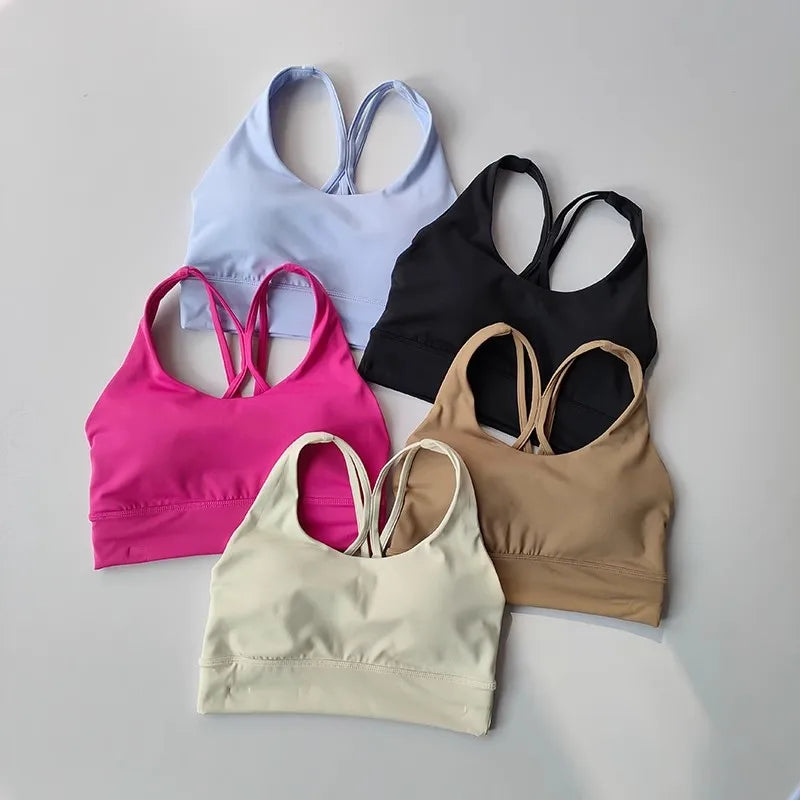 Five vibrant ladies workout clothes set comprising pink, black, blue, beige, and cream sports bras