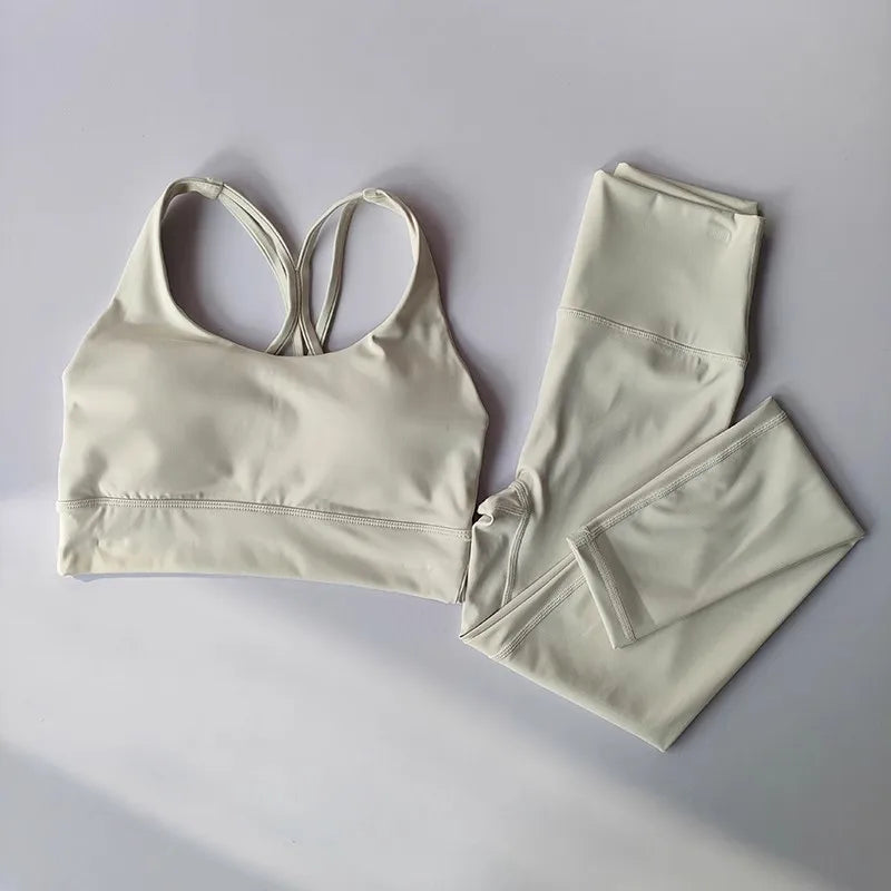 Stylish ladies workout clothes set featuring a light-colored crop top and matching leggings