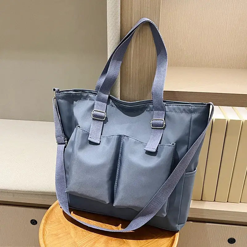 Spacious gray large capacity shopper handbag with multiple pockets and adjustable straps