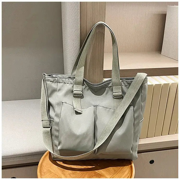Large capacity shopper handbag in soft gray with adjustable straps and multiple pockets