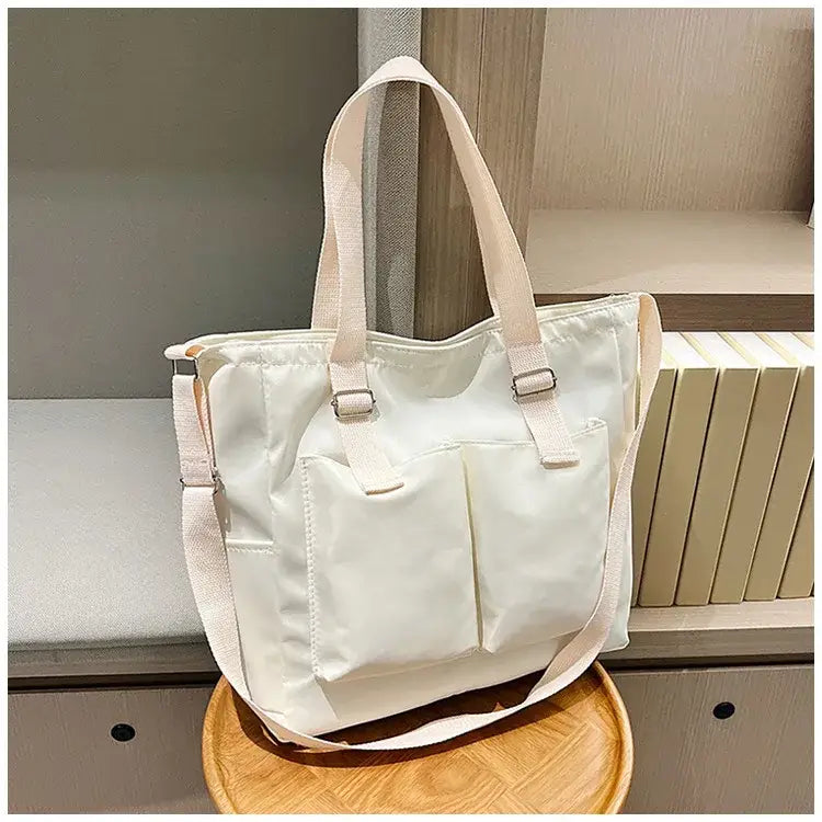 Large capacity shopper handbag in cream with functional front pockets and adjustable straps