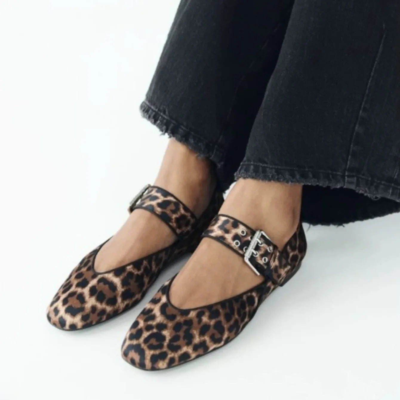 Leopard print pointed toe flats with buckle strap worn with black cropped jeans