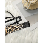 Leopard print push up bra with black straps and hook closure laid on white fur background