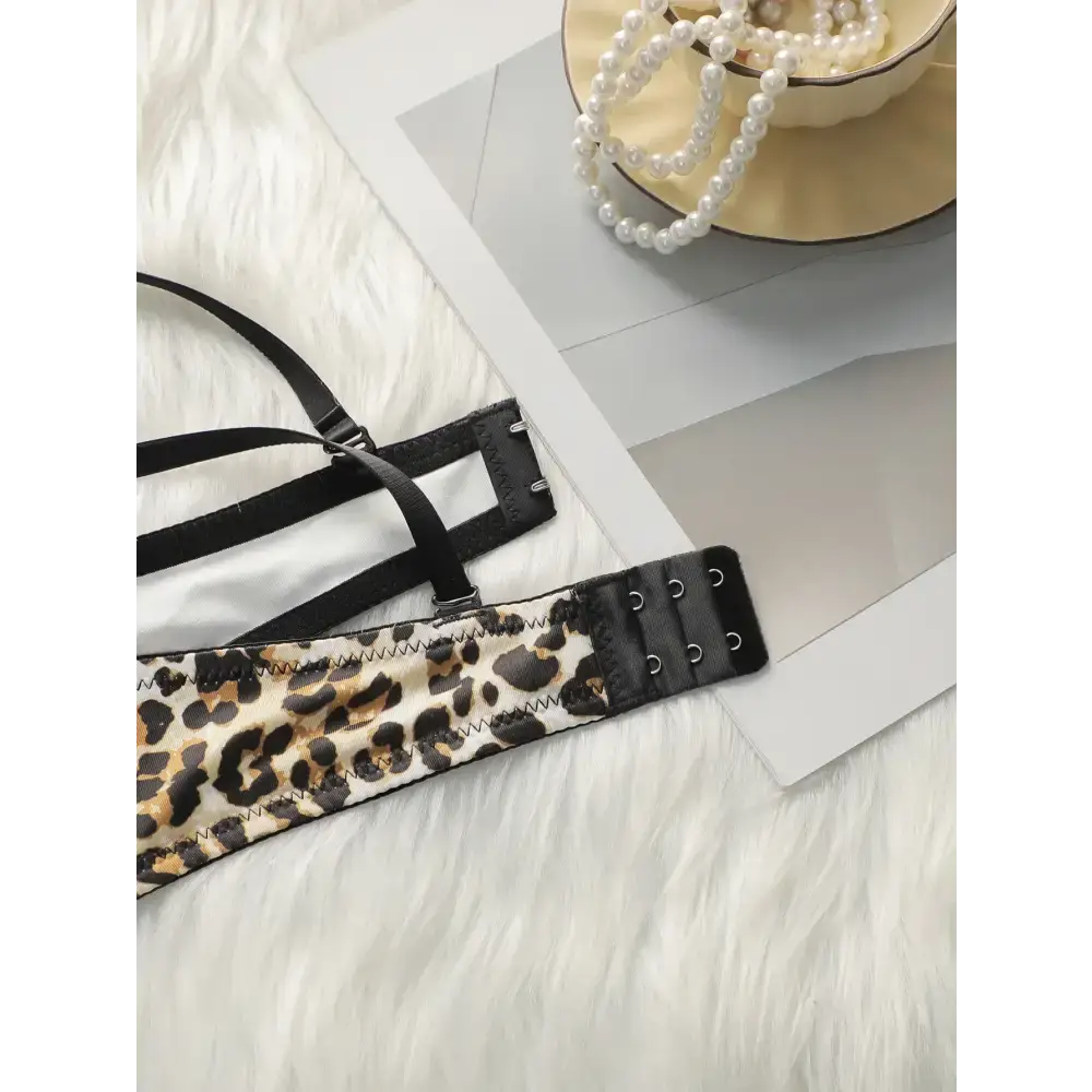 Leopard print push up bra with black straps and hook closure laid on white fur background