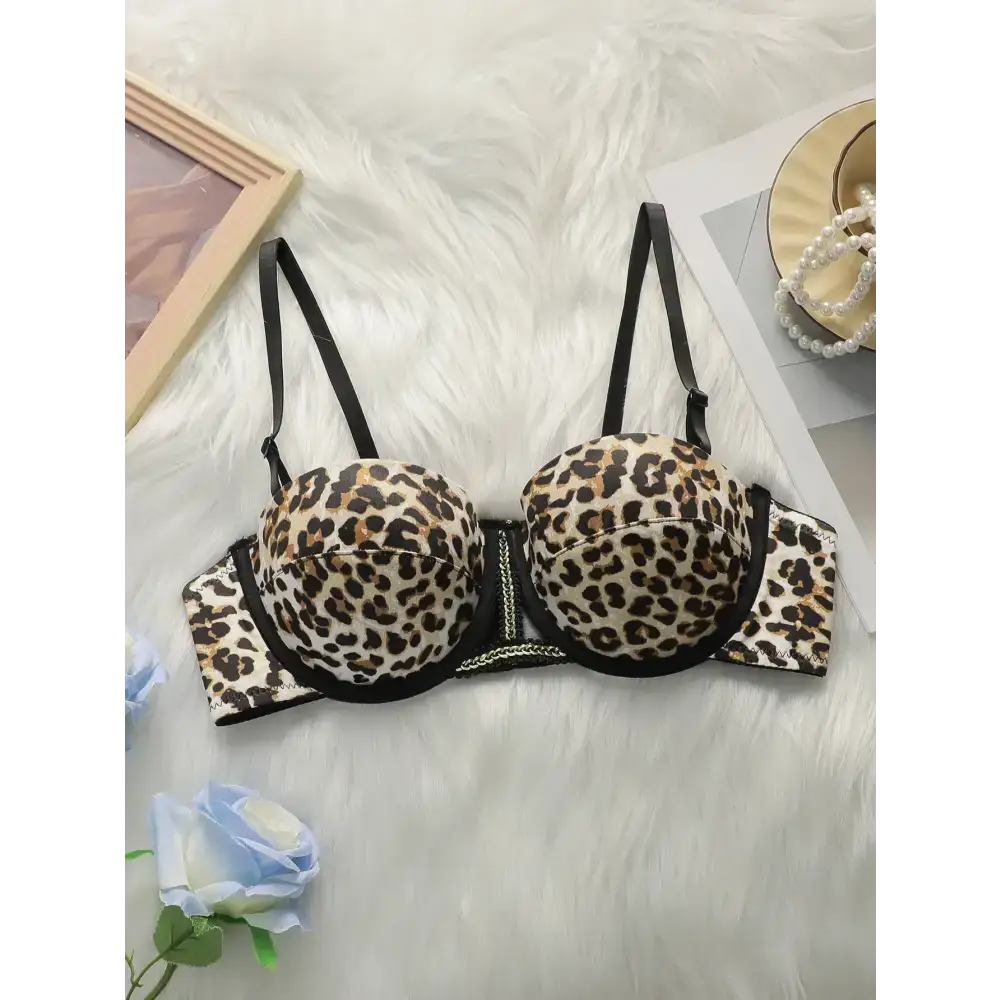 Leopard print push up bra with black straps and underwire support laid on white fur background