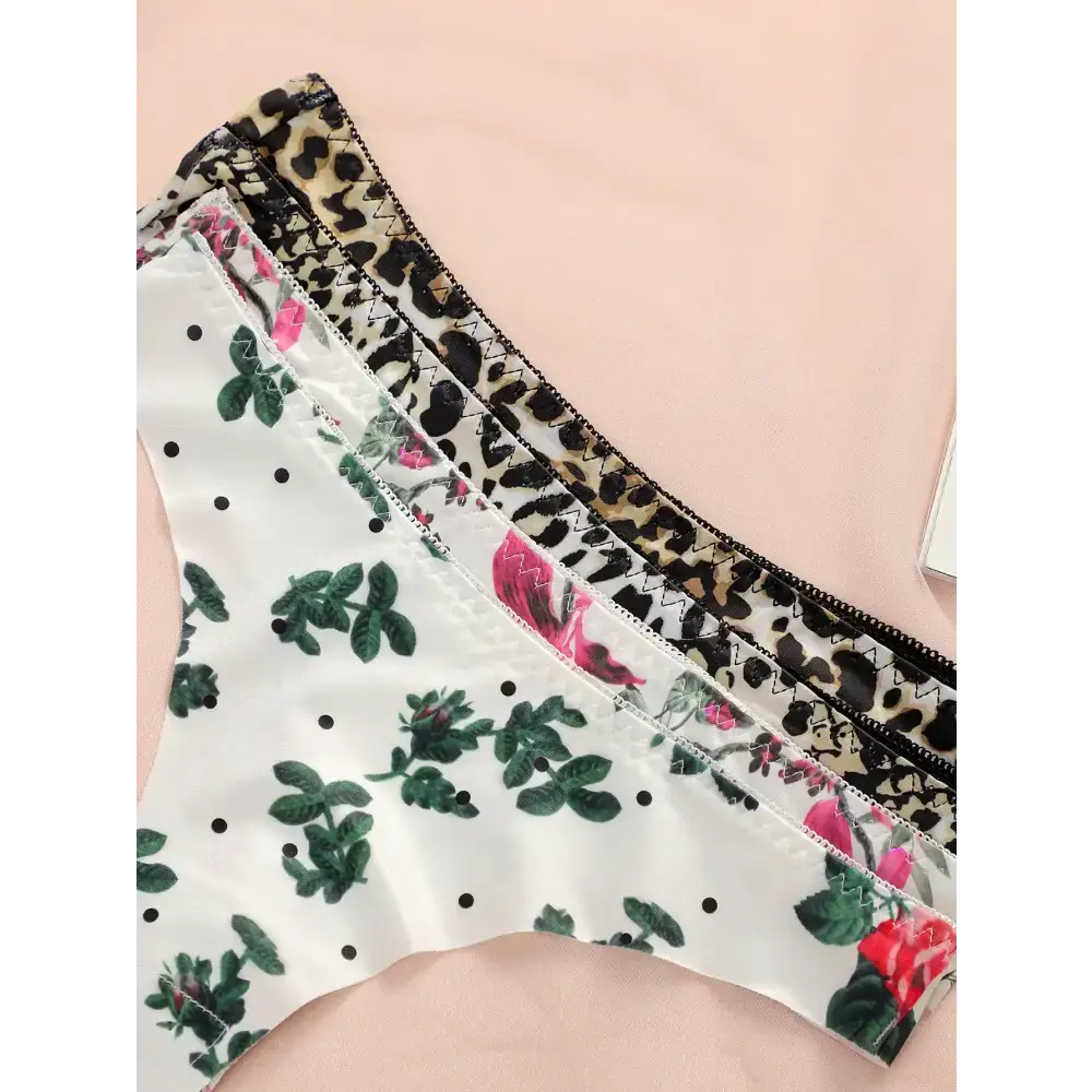 Leopard print thong underwear and floral patterned thong underwear displayed on a pink surface