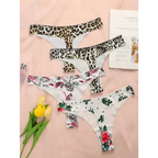 Set of leopard print thong underwear and floral thong underwear laid out on pink background