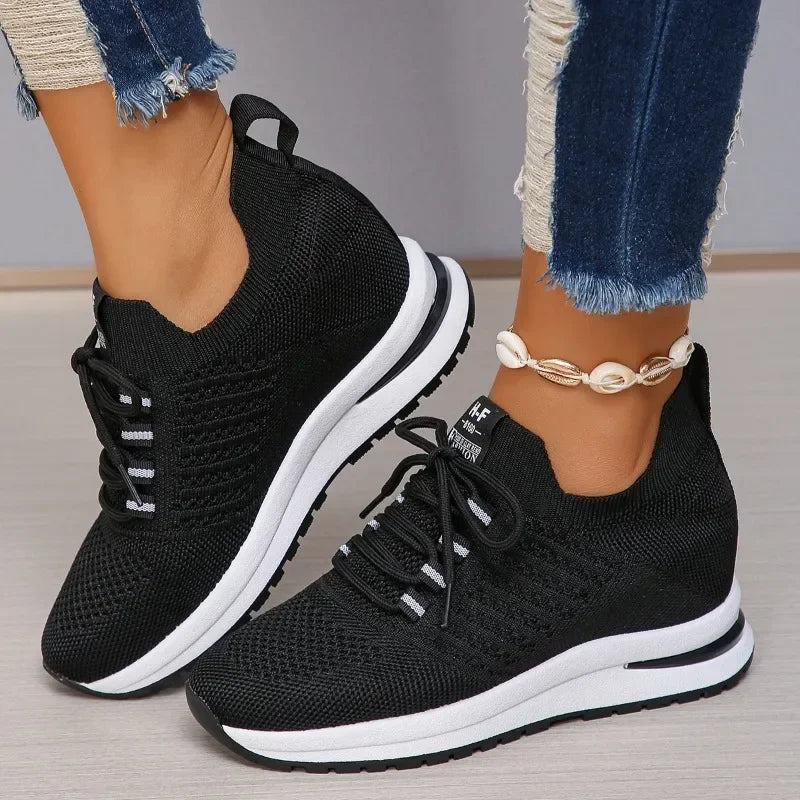 Black lightweight walking shoes with white sole and knit upper worn with blue jeans and shell anklet